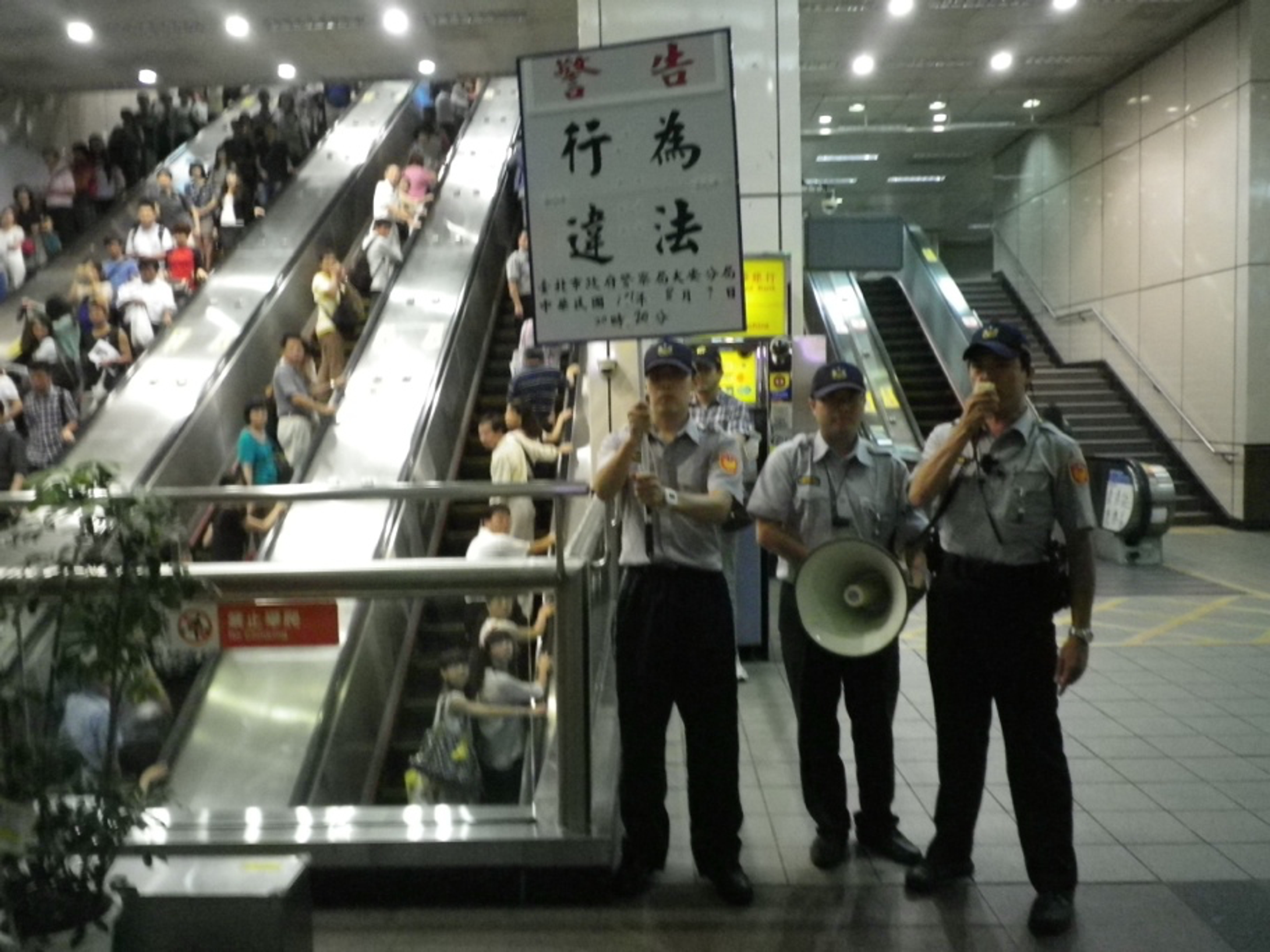 <p class="ql-align-center">2012年8月9日,關廠工人約80人在忠孝復興站向乘客致歉,在站外被警方舉牌/吳永毅提供</p>