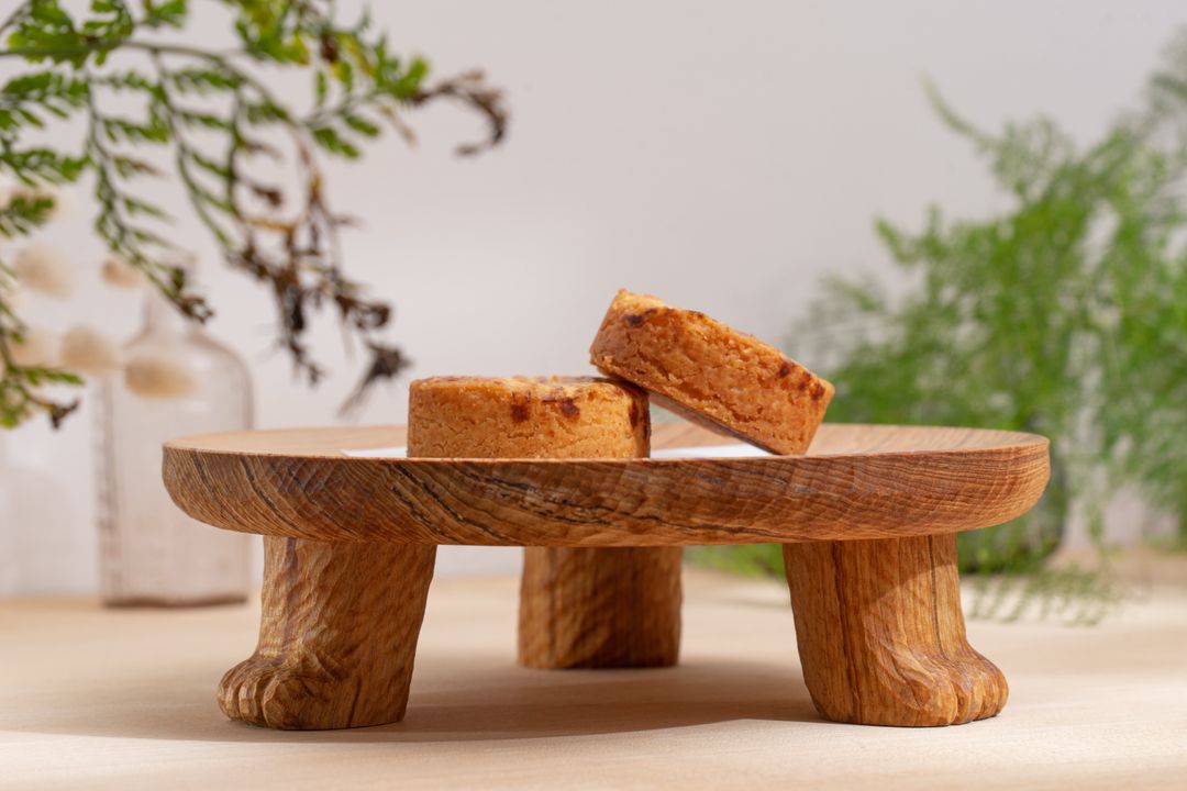 <p>盤面使用車床做出微凹的曲面，並以雕刻刀在側邊留下彷彿毛流的刻紋，讓盤面視覺延伸到雕塑概念製作的盤腳。底下三隻貓腳皆以手工一一刻製，每個三腳貓盤都是獨一無二。</p>